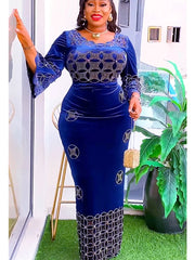A woman wears a long-sleeved blue velvet maxi dress featuring intricate silver circular patterns.