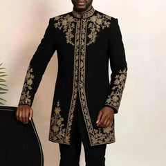 A man wears a black long-sleeved kaftan featuring intricate gold floral embroidery.