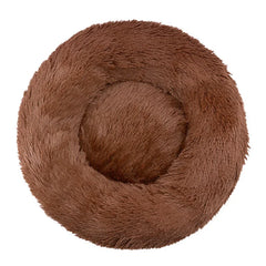 A round, brown plush pet bed with a soft, shaggy texture and a raised rim.