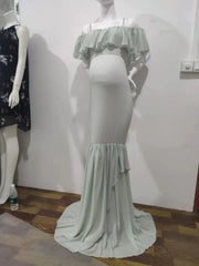 A light green off-shoulder mermaid maternity gown with ruffled chiffon details.
