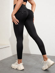 A person wears black high-waisted ankle-length athletic leggings with back cargo pockets.