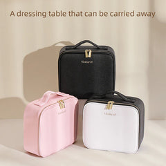 Three portable makeup cases in pink, black, and white with gold zippers and handles.