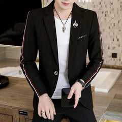 A man wears a black slim-fit suit jacket with red and white sleeve stripes over a white t-shirt.