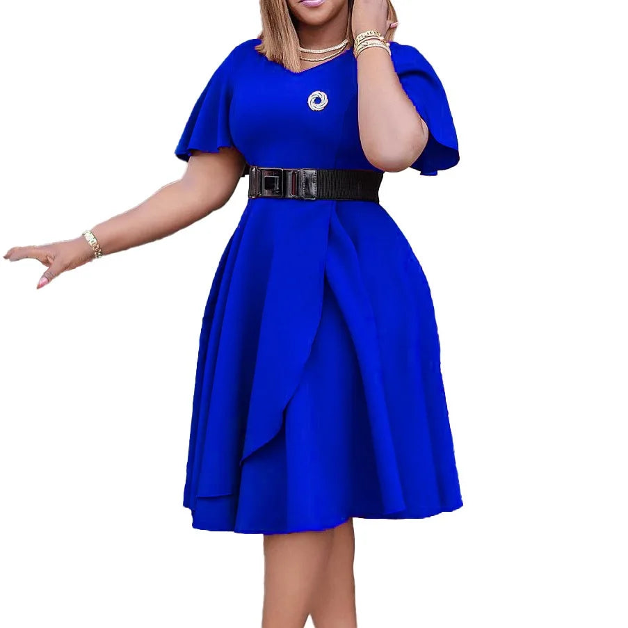 A woman wears a royal blue, short-sleeved, pleated midi dress with a black waist belt.