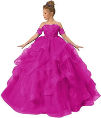 A girl wears a fuchsia off-shoulder ball gown with a sequined bodice and ruffled tulle skirt.