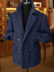 A blue herringbone double-breasted wool blend blazer with a short cut and notched lapels.