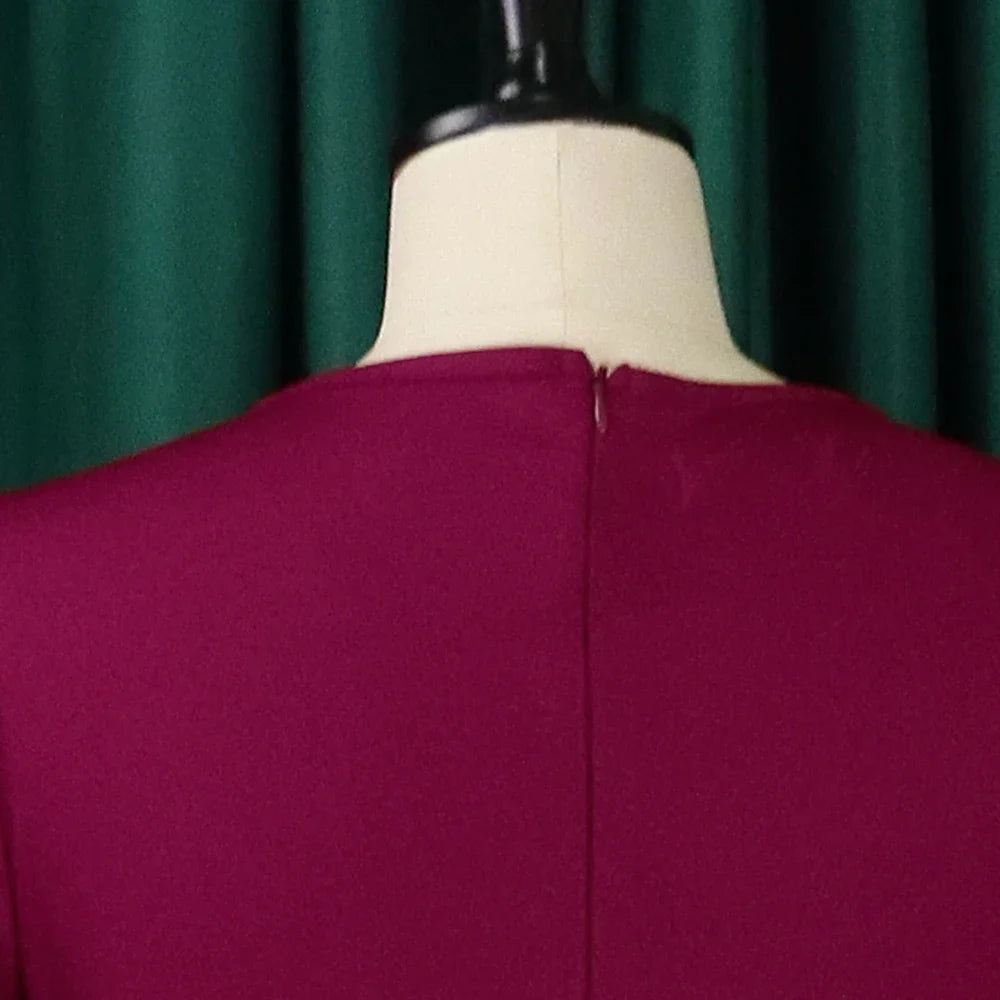 A close-up view of the back of a magenta round-neck dress with a concealed zipper closure.
