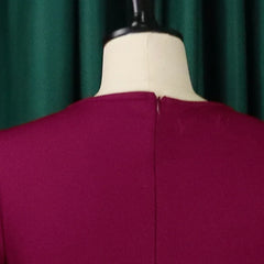 A close-up view of the back of a magenta round-neck dress with a concealed zipper closure.