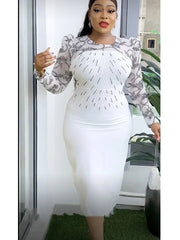 A woman wears a white midi dress with black lace sleeves and a beaded bodice.