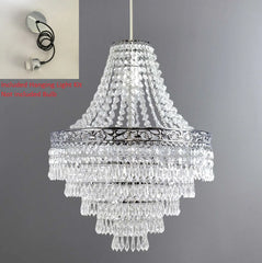 A large tiered acrylic chandelier shade with clear hanging droplets and a decorative metal band.