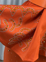 An orange ankle-length dress featuring geometric patterns embellished with yellow and clear crystals.