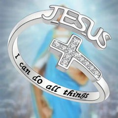 A silver-colored ring featuring a zircon-encrusted cross and the inscription I can do all things.