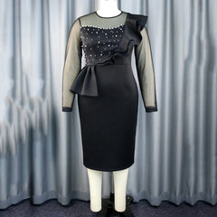 A black sheath dress with long sheer sleeves, a beaded bodice, and ruffled shoulder detail.