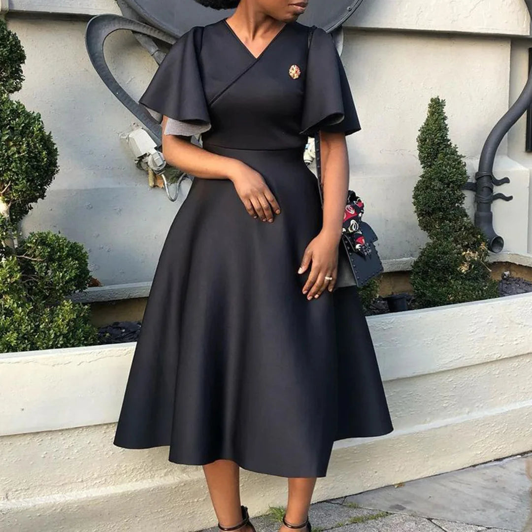 A woman wears a black midi-length A-line dress with a V-neck and butterfly sleeves.