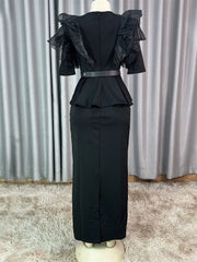 A black ankle-length dress with ruffled sleeves, a peplum waist, and a back zipper closure.
