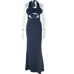 A black ankle-length halter dress featuring floral accents on the bodice and a cutout waist.