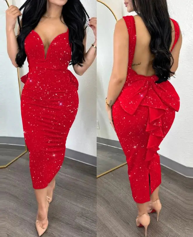 A woman wears a red, mid-calf, sleeveless sheath dress with a plunging neckline and back bow.