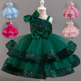 A sleeveless, knee-length sequined ball gown for girls with a large bow and tiered tulle skirt.