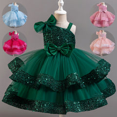 A sleeveless, knee-length sequined ball gown for girls with a large bow and tiered tulle skirt.