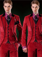 A man wears a three-piece red velvet suit with a black vest, black trim, and a patterned shirt.