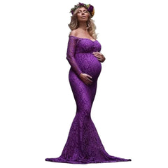 A pregnant woman wears a long-sleeved, purple lace mermaid-style maternity gown for a photoshoot.