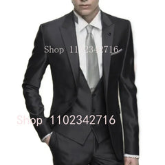 A man wearing a slim-fit silver grey three-piece suit with a matching tie and formal blazer.