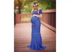 A pregnant woman wears a royal blue, short-sleeve, V-neck lace maternity maxi dress.
