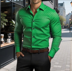 A man wears a long-sleeved green button-down shirt with a black polka dot pattern.