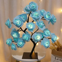 A decorative table lamp shaped like a tree with glowing blue rose flowers.