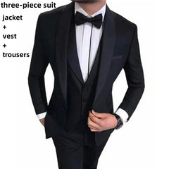 A man wears a black three-piece tuxedo featuring a shawl lapel, a vest, and a bow tie.