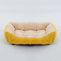 A rectangular pet bed with a yellow corduroy exterior and a soft, beige plush interior.