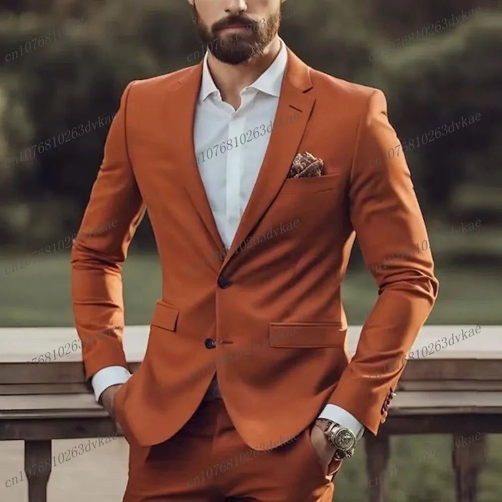 A man wears a brown two-piece formal suit with a white shirt and a patterned pocket square.