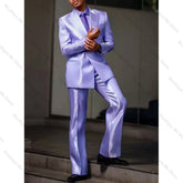 A man wears a shiny purple satin two-piece suit with a peak lapel jacket and matching trousers.