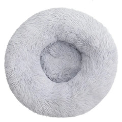 A round, light gray plush pet bed with a soft, shaggy texture.