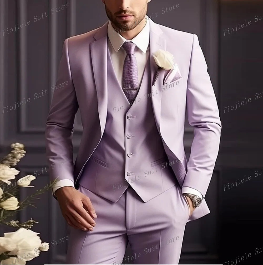 A man wears a light purple three-piece suit with a matching vest, tie, and white lapel flower.