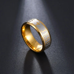 A gold-toned stainless steel ring featuring an engraved cross and the word Jesus.