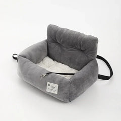 A grey plush car pet seat with a white interior and a safety tether on a white background.