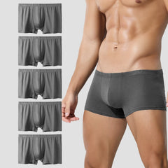 A set of five grey men's boxer briefs shown stacked next to a model wearing one pair.
