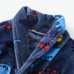 A close-up of a soft, navy blue flannel children's bathrobe featuring a colorful dinosaur pattern.