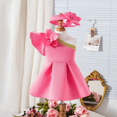 A pink sleeveless A-line dress for girls featuring a large flower accent and a matching headband.