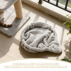 A round, plush grey pet hammock bed with a spoon-shaped design sits on a tiled floor.