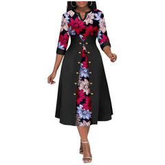 A woman wears a mid-calf V-neck dress featuring a floral print bodice and sleeves with a solid black button-down overlay.