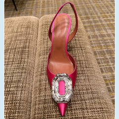 A bright pink pointed-toe stiletto slingback heel featuring a large rectangular rhinestone buckle.