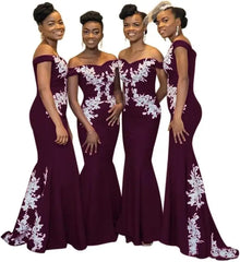 Four women wear matching burgundy off-the-shoulder mermaid dresses with white floral lace accents.