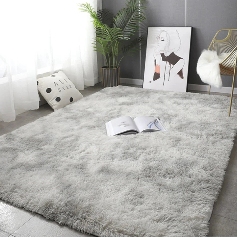 A rectangular, plush gray area rug with a soft, fluffy texture laid on a tiled floor.