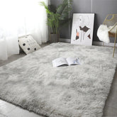 A rectangular, plush gray area rug with a soft, fluffy texture laid on a tiled floor.
