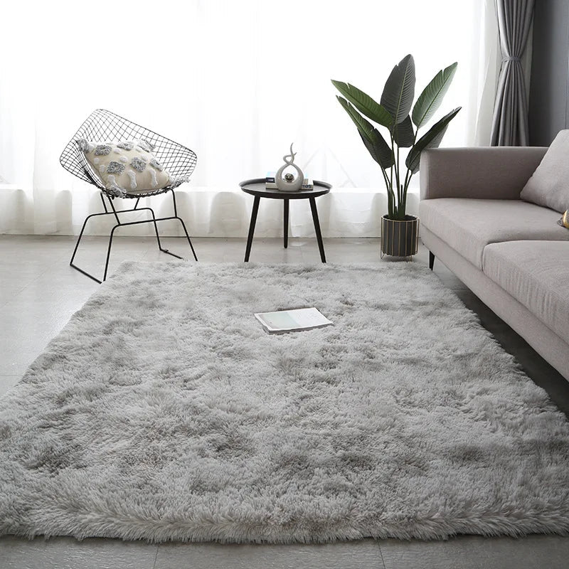 A rectangular, plush gray area rug with a soft, shaggy texture placed in a modern living room.