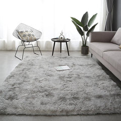 A rectangular, plush gray area rug with a soft, shaggy texture placed in a modern living room.