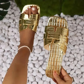 A pair of gold metallic flat sandals with a crocodile-embossed texture and square toe.