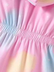 A close-up of a pink, blue, and yellow pastel unicorn-patterned coat with a gathered elastic waist.